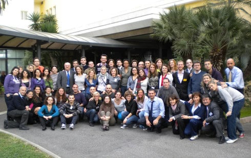 Immagine di un gruppo di centinaia di studenti universitari sordi e sordociechi, tutti insieme e felici, posando per la foto dopo aver concluso l’evento